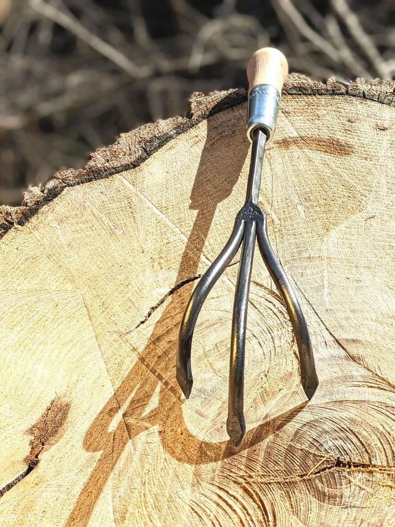 3 Tine Cultivator, Hand Forged Garden Tool, Lifetime Guarantee on wooden background
