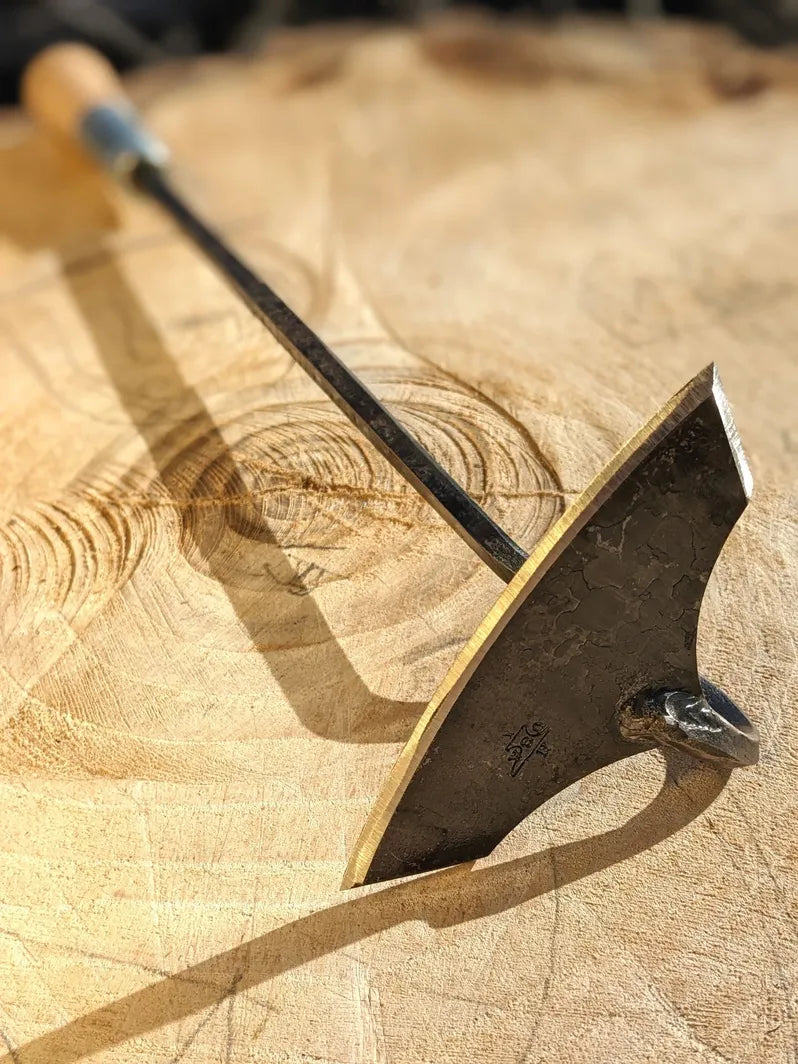 Batwing Hoe, Cotton Hoe Hand Forged Garden Tool by Homestead Iron close up sharp tool head on wooden background. 