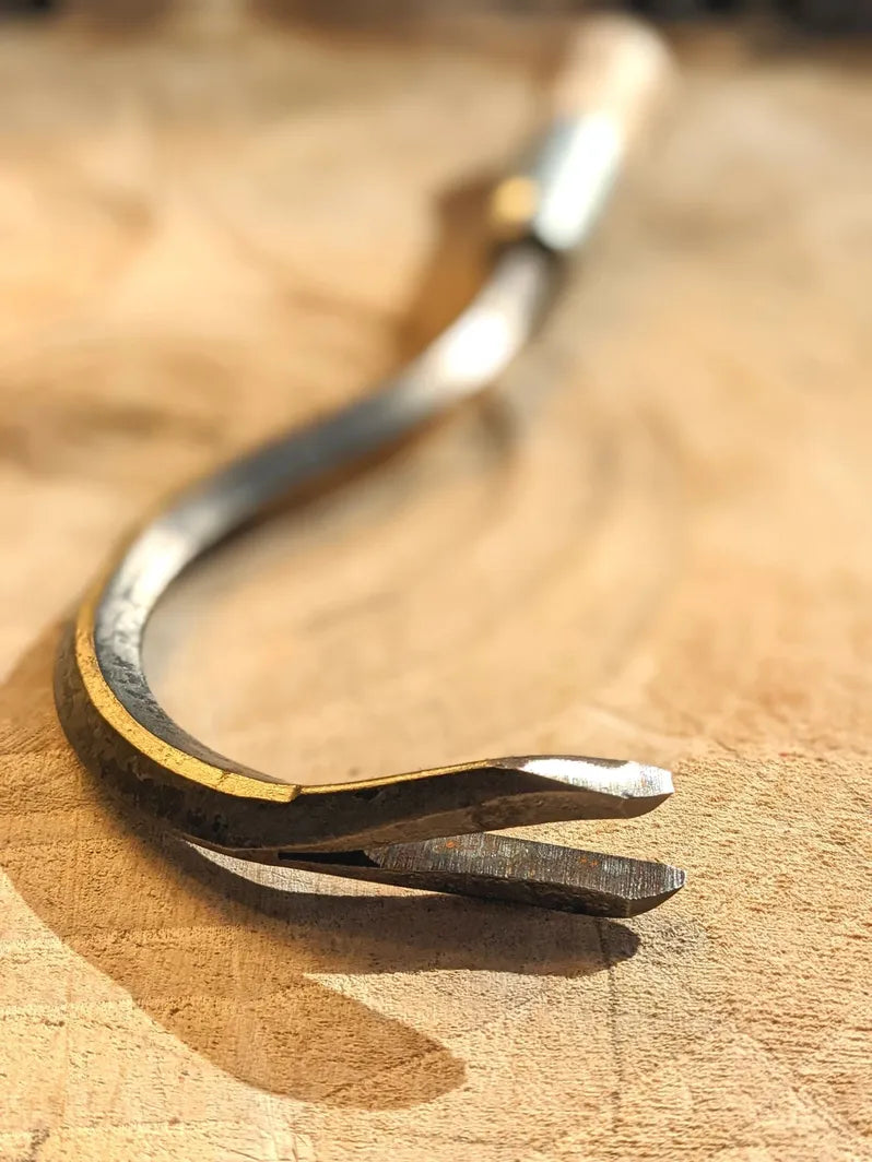Weed Yanker, Hand Forged Garden Tool close up of tool head on wooden background. 